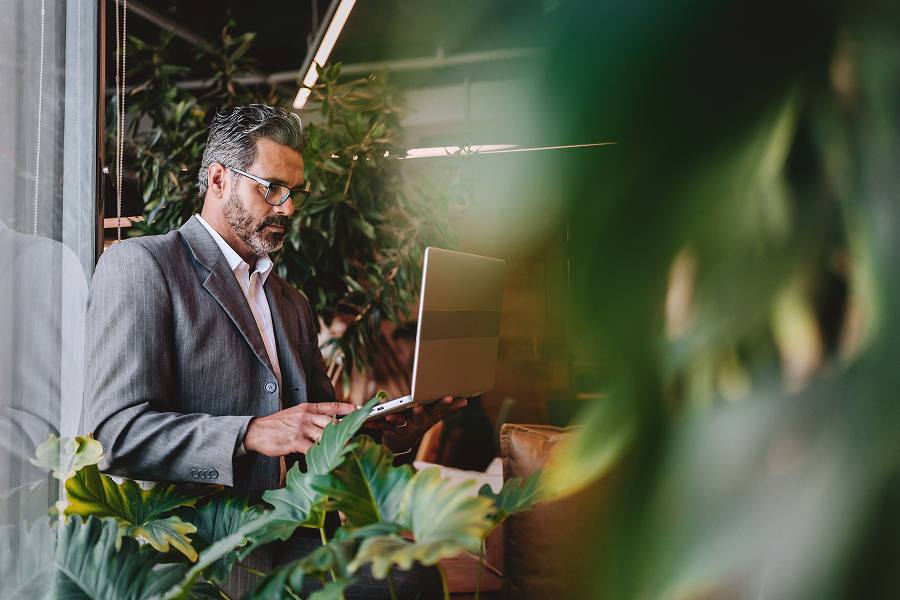A male employee thinking while using a laptop