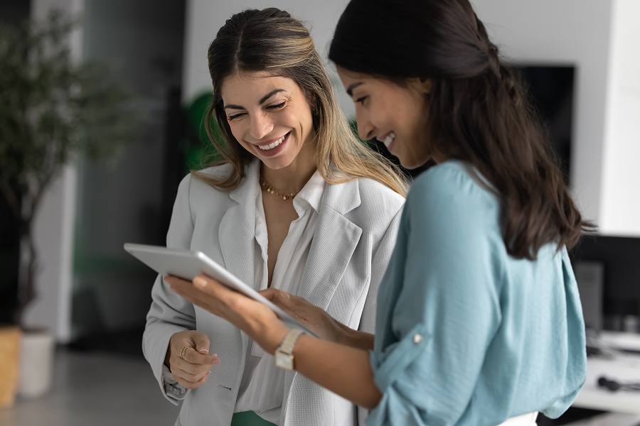 Two female employees looking at a tablet